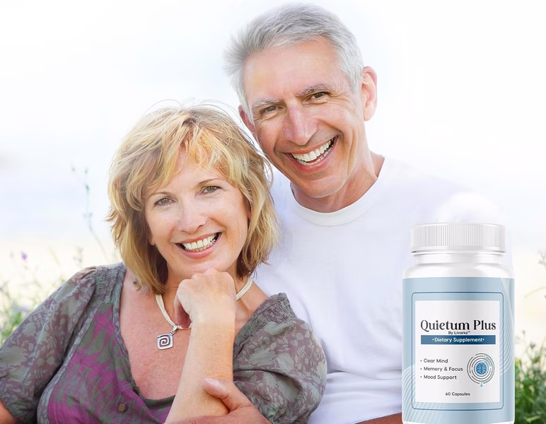 A medical professional in a white coat pointing to an anatomical model of the human ear.